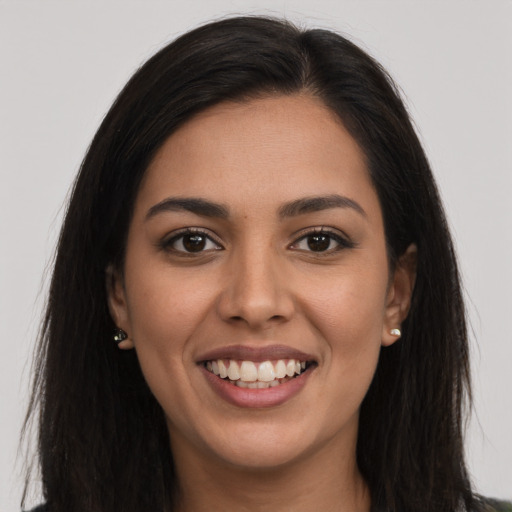 Joyful latino young-adult female with long  brown hair and brown eyes