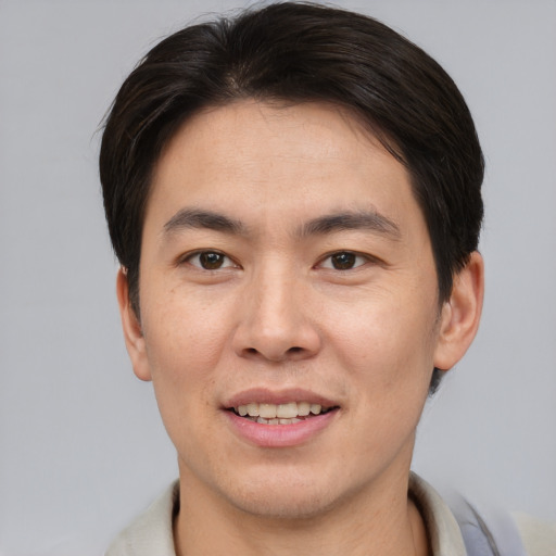 Joyful asian young-adult male with short  brown hair and brown eyes