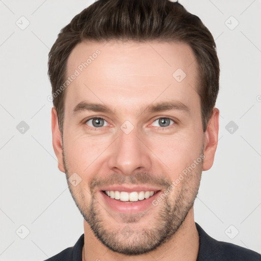 Joyful white young-adult male with short  brown hair and grey eyes