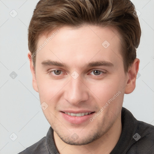 Joyful white young-adult male with short  brown hair and grey eyes