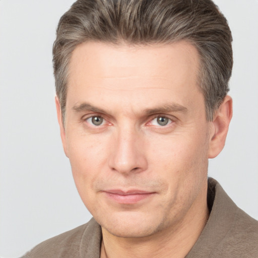 Joyful white adult male with short  brown hair and grey eyes