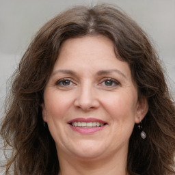 Joyful white adult female with long  brown hair and grey eyes