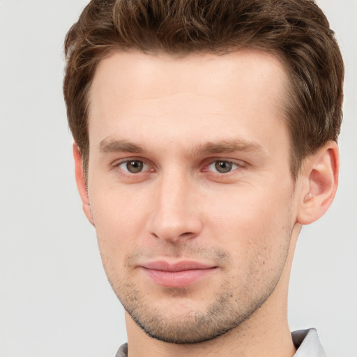 Joyful white young-adult male with short  brown hair and grey eyes