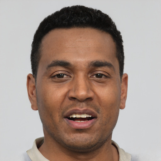 Joyful black young-adult male with short  black hair and brown eyes
