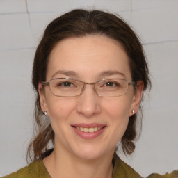 Joyful white adult female with medium  brown hair and grey eyes