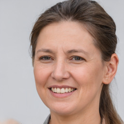 Joyful white adult female with long  brown hair and grey eyes