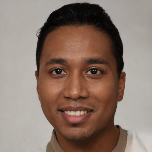 Joyful black young-adult male with short  black hair and brown eyes