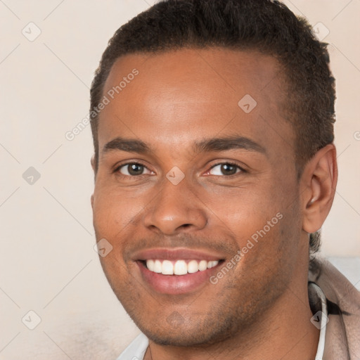 Joyful black young-adult male with short  brown hair and brown eyes