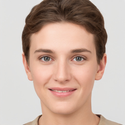 Joyful white young-adult female with short  brown hair and grey eyes