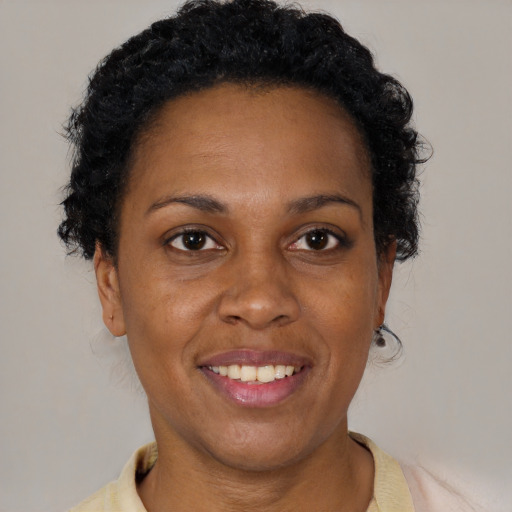 Joyful black adult female with short  brown hair and brown eyes