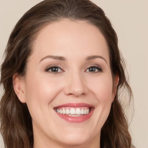 Joyful white young-adult female with long  brown hair and brown eyes