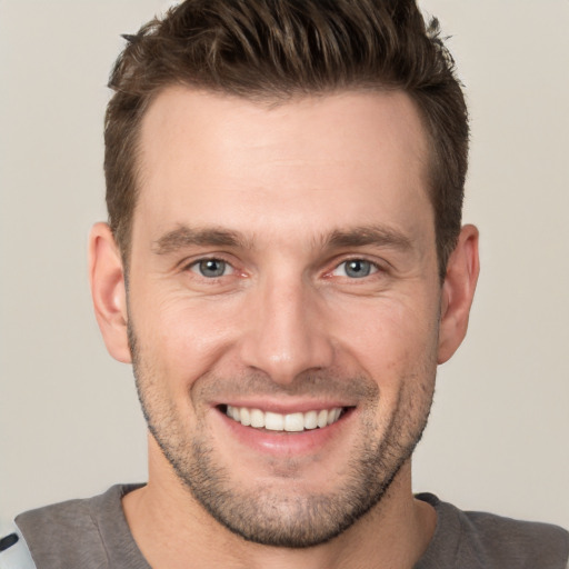 Joyful white young-adult male with short  brown hair and brown eyes