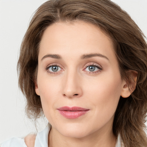 Joyful white young-adult female with medium  brown hair and blue eyes