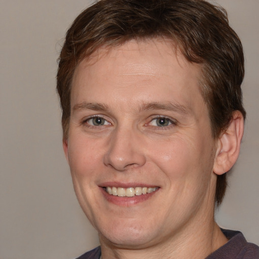 Joyful white adult male with medium  brown hair and brown eyes