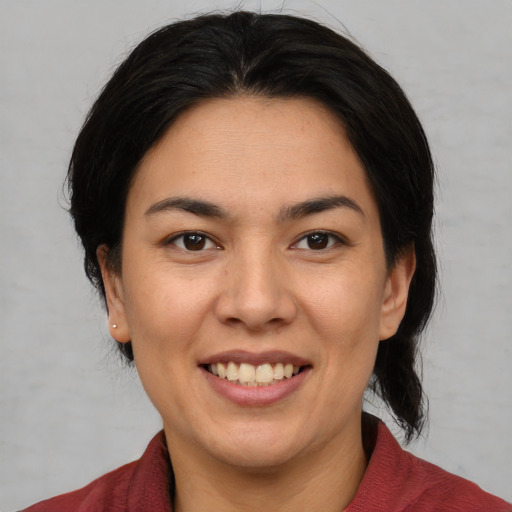 Joyful latino young-adult female with medium  brown hair and brown eyes