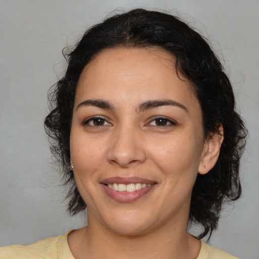 Joyful latino young-adult female with medium  black hair and brown eyes