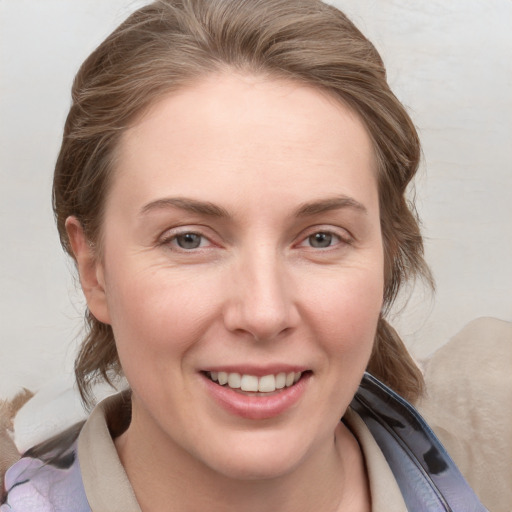 Joyful white young-adult female with medium  brown hair and blue eyes