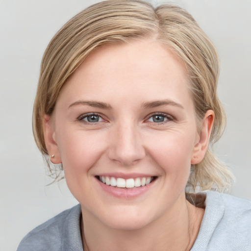 Joyful white young-adult female with medium  brown hair and blue eyes