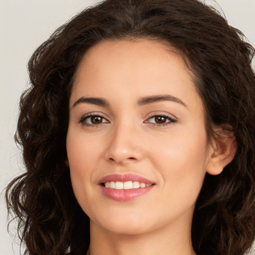 Joyful white young-adult female with long  brown hair and brown eyes