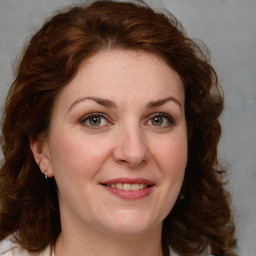 Joyful white young-adult female with medium  brown hair and green eyes