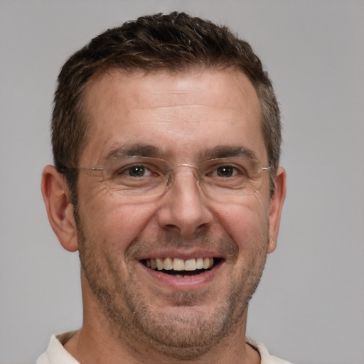 Joyful white adult male with short  brown hair and brown eyes