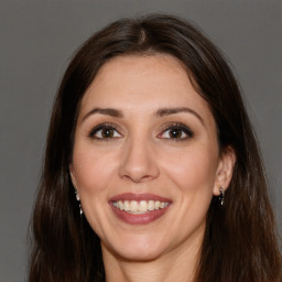 Joyful white adult female with long  brown hair and brown eyes