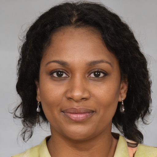 Joyful black young-adult female with medium  brown hair and brown eyes