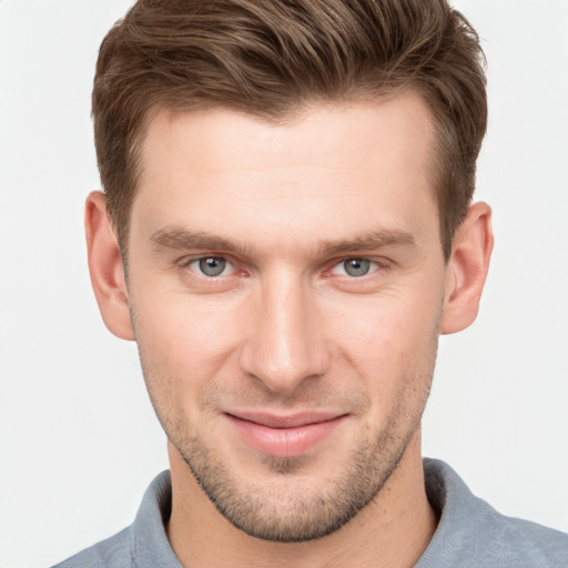 Joyful white young-adult male with short  brown hair and grey eyes