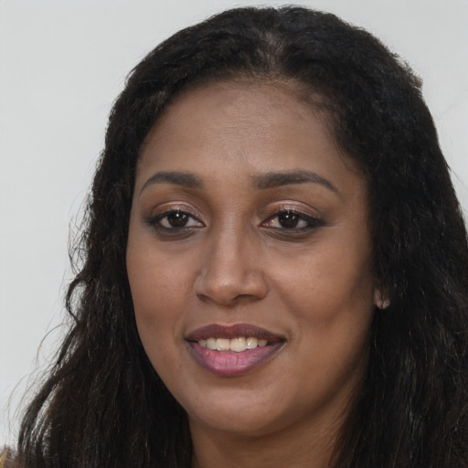 Joyful black young-adult female with long  brown hair and brown eyes