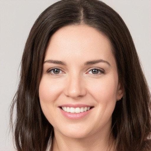 Joyful white young-adult female with long  brown hair and brown eyes