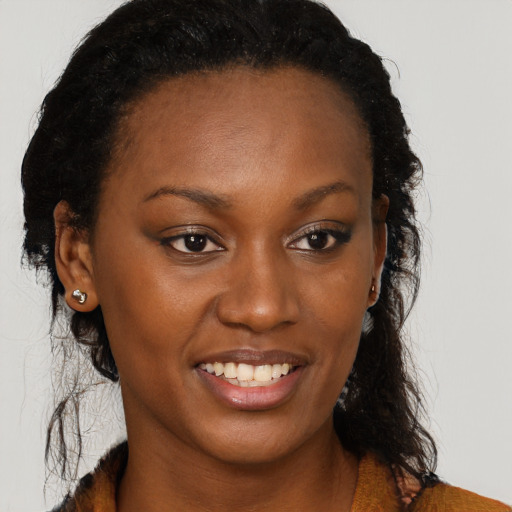 Joyful black young-adult female with long  brown hair and brown eyes
