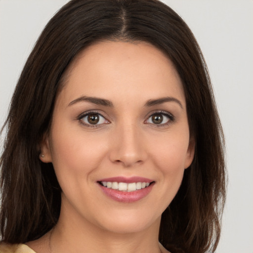 Joyful white young-adult female with long  brown hair and brown eyes