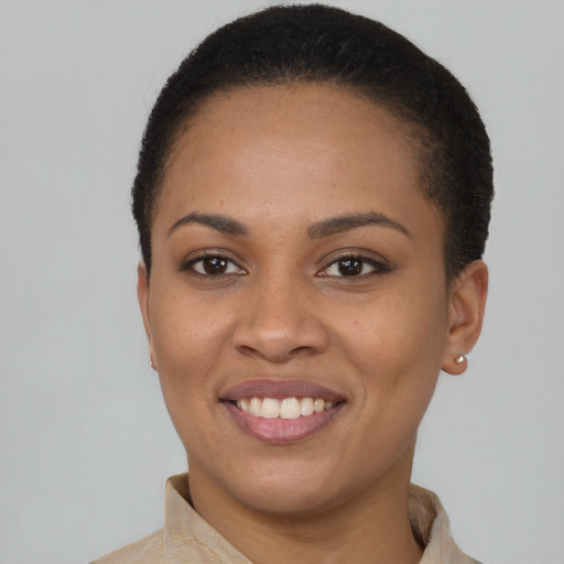 Joyful black young-adult female with short  brown hair and brown eyes
