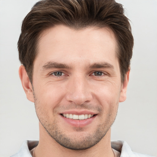 Joyful white young-adult male with short  brown hair and grey eyes