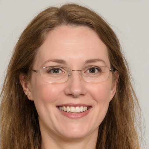 Joyful white adult female with long  brown hair and green eyes