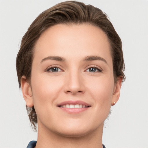 Joyful white young-adult female with medium  brown hair and grey eyes