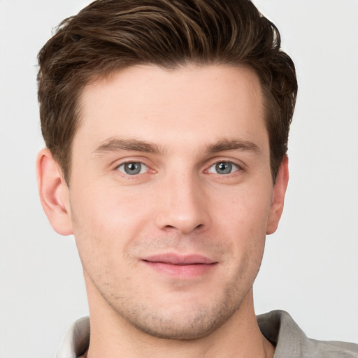 Joyful white young-adult male with short  brown hair and grey eyes