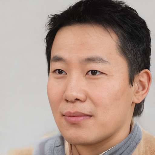 Joyful asian adult male with short  brown hair and brown eyes