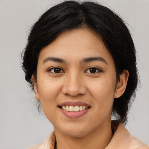 Joyful asian young-adult female with medium  brown hair and brown eyes