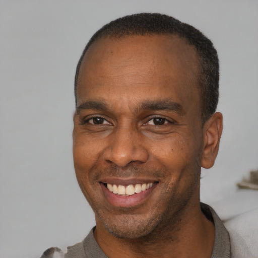 Joyful latino adult male with short  brown hair and brown eyes