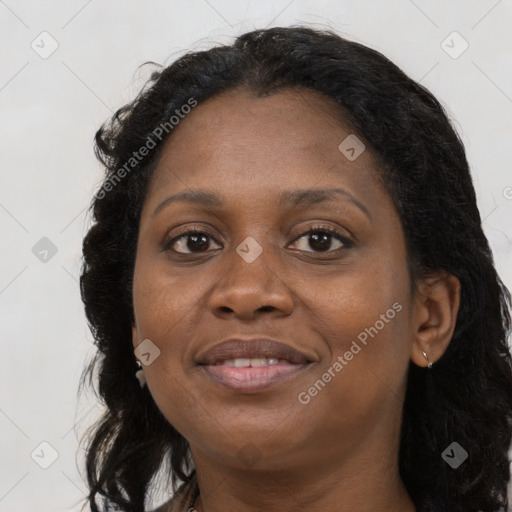 Joyful black adult female with long  black hair and brown eyes