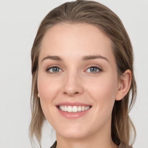 Joyful white young-adult female with medium  brown hair and blue eyes