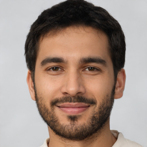 Joyful latino young-adult male with short  black hair and brown eyes