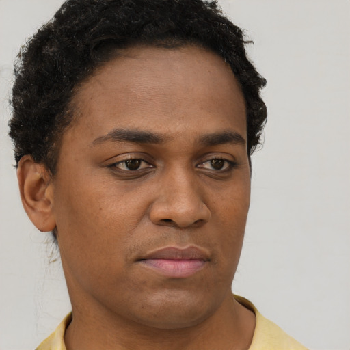 Joyful black young-adult male with short  brown hair and brown eyes