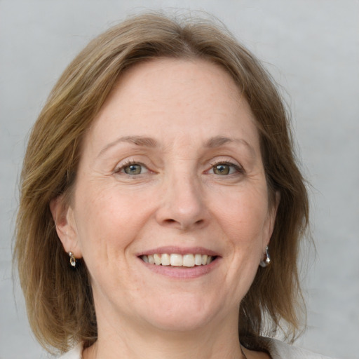 Joyful white adult female with medium  brown hair and blue eyes