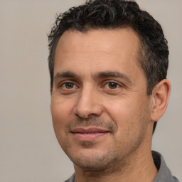 Joyful white adult male with short  black hair and brown eyes