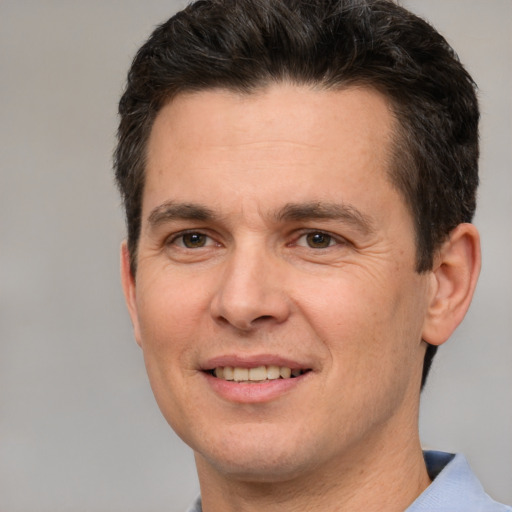 Joyful white adult male with short  brown hair and brown eyes