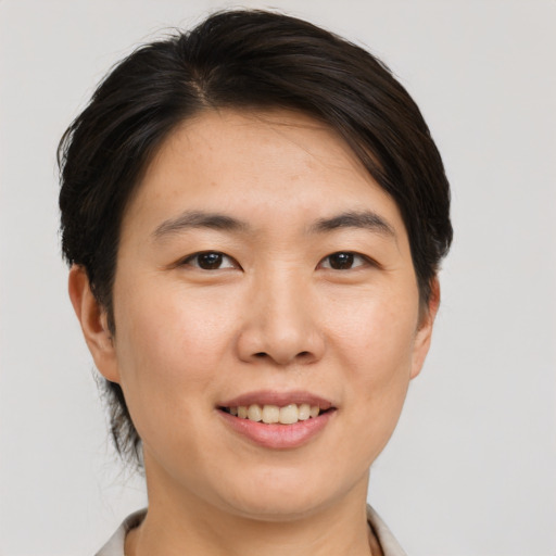 Joyful asian young-adult female with short  brown hair and brown eyes