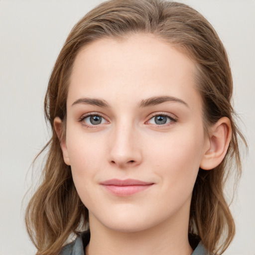 Joyful white young-adult female with long  brown hair and blue eyes