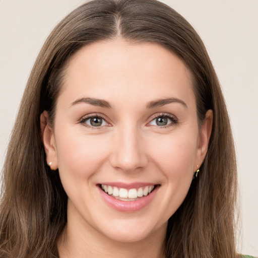 Joyful white young-adult female with long  brown hair and green eyes